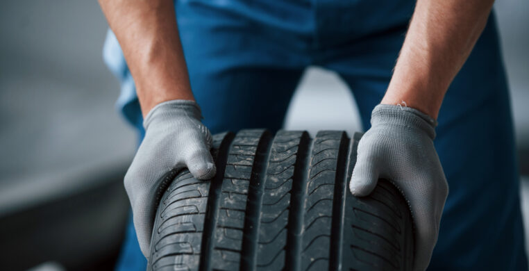 dirt-wheel-mechanic-holding-tire-repair-garage-replacement-winter-summer-tires
